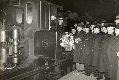 97413 Afbeelding van het overhandigen van bloemen aan de machinist van de laatst vertrekkende trein vanaf het ...